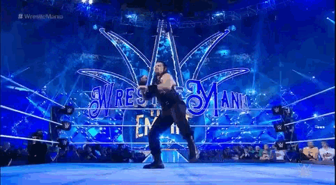 roman reigns is dancing in a wrestling ring during a wrestlemania match .