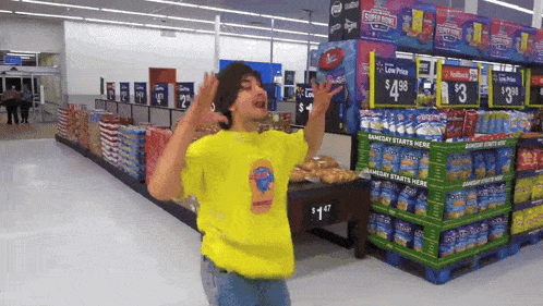 a man in a yellow shirt stands in front of a sign that says $ 1.98