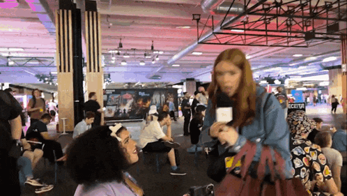 a woman holding a microphone in a crowded room with a sign that says cctv
