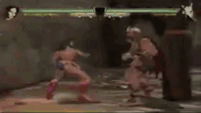 a man is playing a video game while a woman is standing in the background .