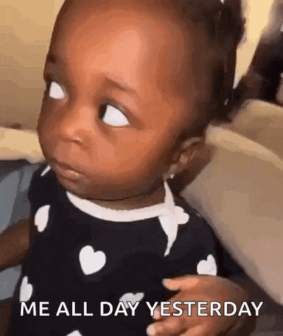 a baby is making a funny face and saying `` me all day yesterday '' while sitting on a couch .