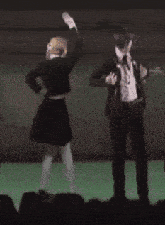 a man and a woman are dancing on a green stage