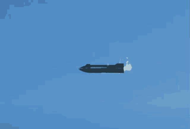 a rocket flies through a blue sky with smoke coming out of it