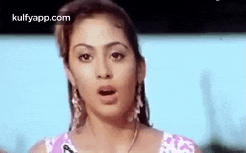 a close up of a woman 's face with her mouth open and a surprised look on her face .