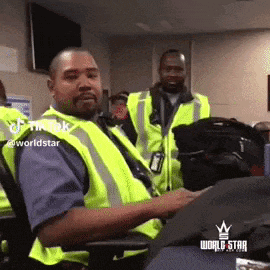 a man wearing a neon yellow vest is sitting in a chair .