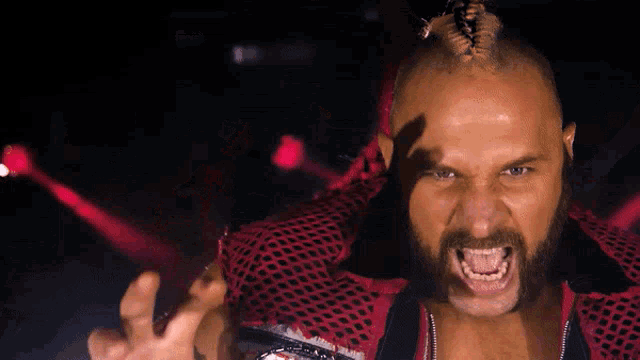 a man with a beard and a mohawk is screaming with his mouth open