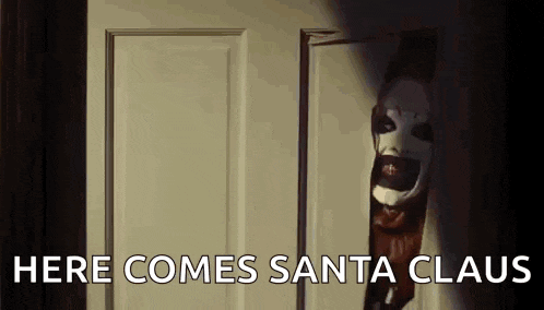 a creepy clown is peeking out of a door with the words `` here comes santa claus '' written on it .