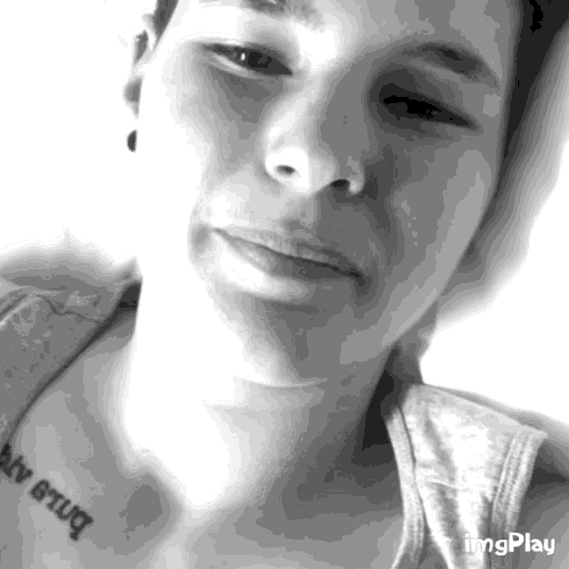 a black and white photo of a woman with a tattoo on her chest that says ' i love you '