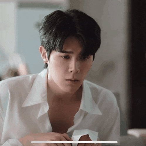 a man in a white shirt looks at something