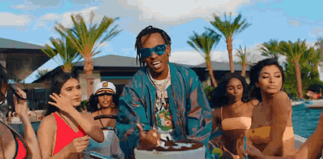 a man in sunglasses is standing in front of a group of women in bikinis