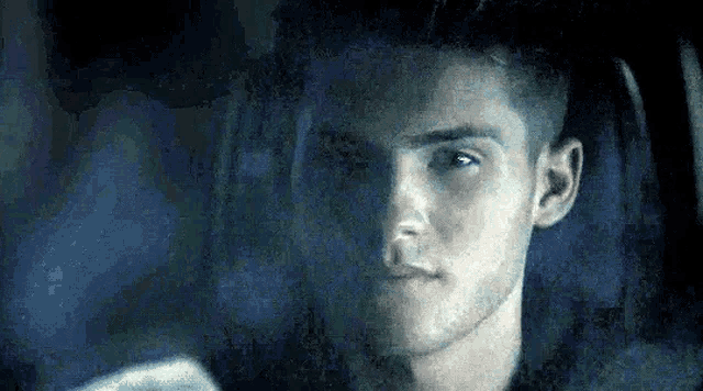a close up of a man 's face in a car with smoke coming out of the window .