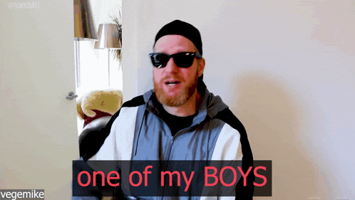 a man wearing sunglasses and a hat says " one of my boys "