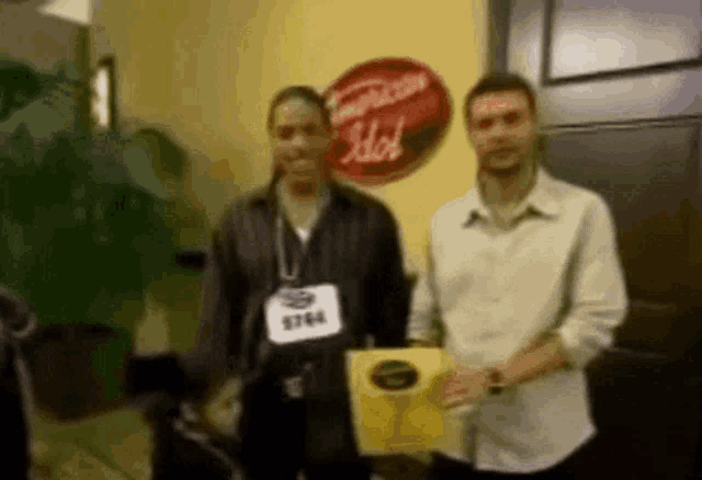 two men standing next to each other in front of a sign that says american hot