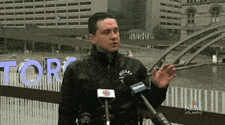 a man speaking into a microphone in front of a sign that says tor on it