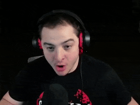 a man wearing headphones is sitting in front of a microphone and making a funny face .