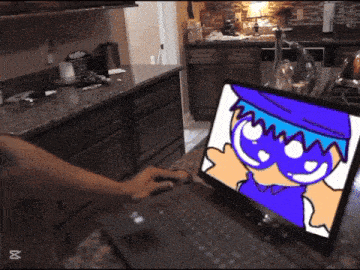 a person is typing on a laptop with a cartoon character on it