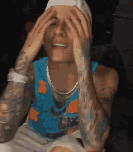 a man covering his eyes with his hands and wearing a shirt that says space jam on it