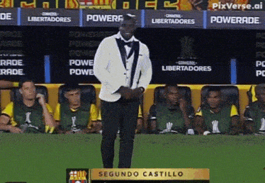 a man in a tuxedo stands in front of a podium that says segundo castillo on it