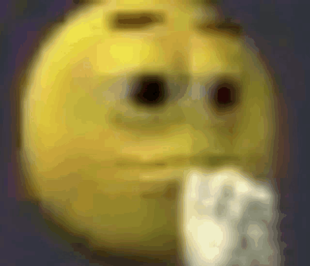 a blurry picture of a yellow smiley face with a hand sticking out of it .