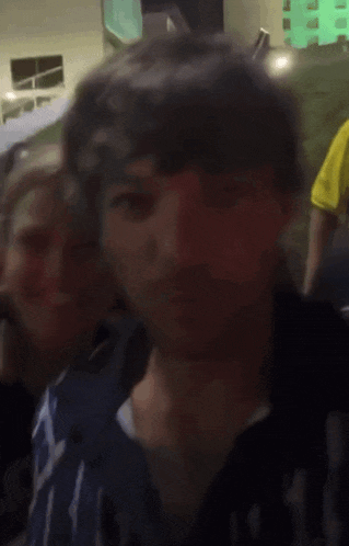 a blurry picture of a man 's face with a yellow shirt on