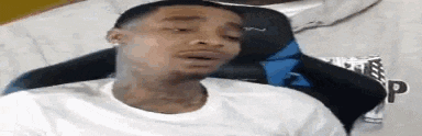 a man is sitting in a chair with his mouth open and making a funny face .