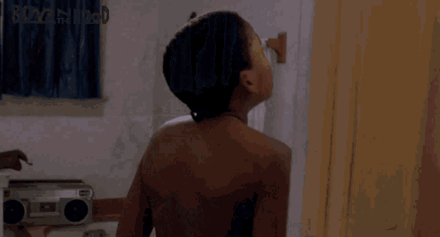 a shirtless boy is standing in a bathroom with the words boyz the hood on the bottom