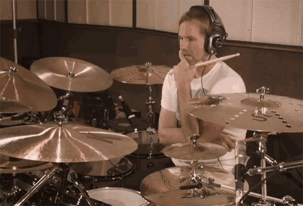 a man wearing headphones is playing a drum set with a cymbal that says ' nc ' on it