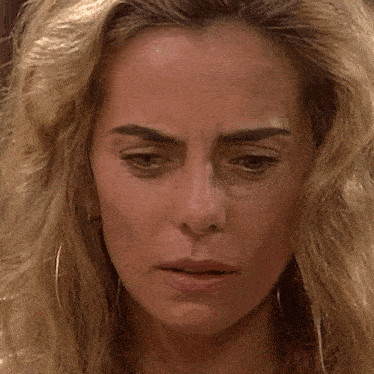 a close up of a blonde woman 's face with a serious look on her face