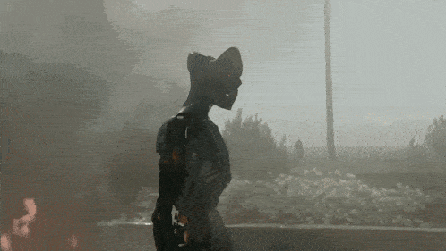 a statue of a man in a cowboy hat is walking in the fog