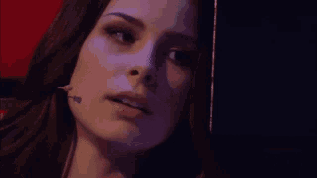 a close up of a woman 's face in a dark room smiling