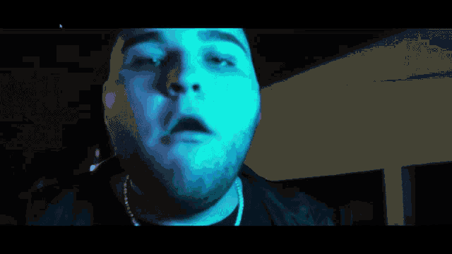 a close up of a man 's face with a blue background