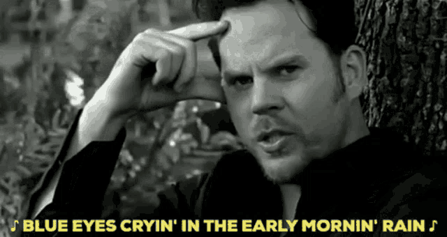 a black and white photo of a man with the words blue eyes cryin ' in the early mornin ' rain above him