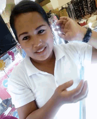 a woman in a white polo shirt is smiling and holding something in her hands