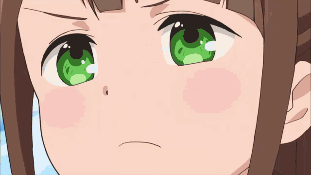 a girl with brown hair and green eyes is making a funny face