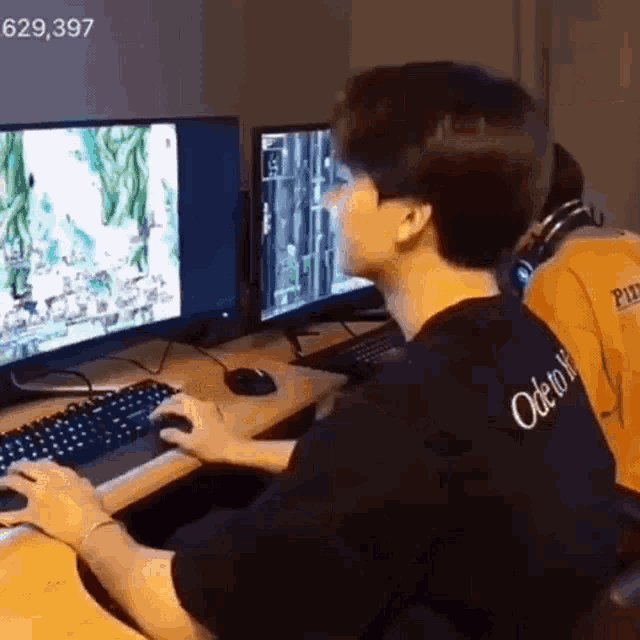 a man is playing a video game on a computer while sitting at a desk .