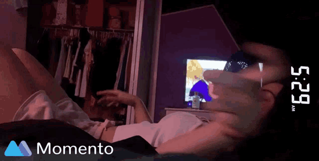 a woman is laying on a bed with a clock that says 5:29 am