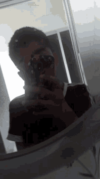 a man taking a picture of himself in a mirror with a red phone