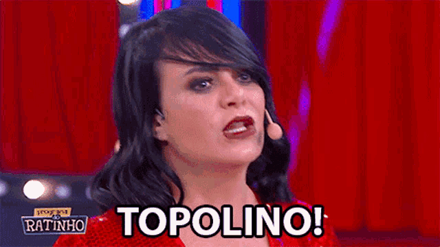a woman in a red dress says topolino on a red curtain