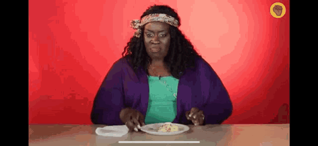 a woman sitting at a table with a plate of food in front of her