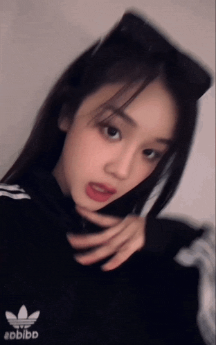 a blurry picture of a girl wearing a black adidas sweatshirt