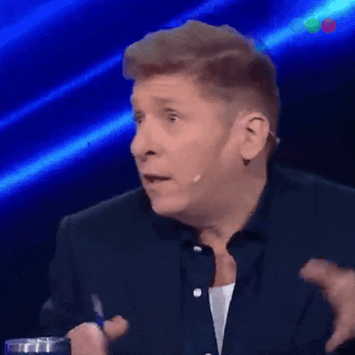a man in a suit and tie is talking on a stage