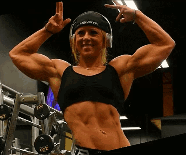 a woman in a gym wearing headphones and a monster hat