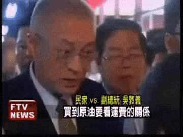 a man in a suit and tie stands in front of a sign that says ftv news