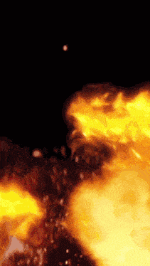 a close up of a fire with sparks flying in the air