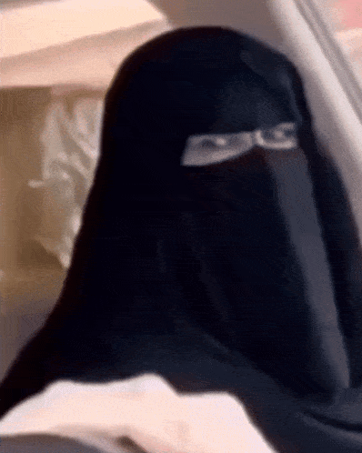 a woman in a niqab is sitting in a car .