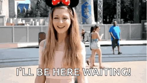 a woman wearing a minnie mouse headband says i 'll be here waiting