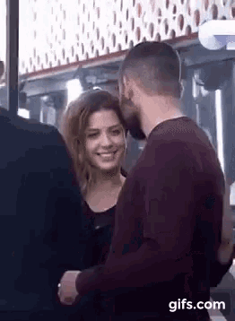 a man and a woman are standing next to each other in a room .