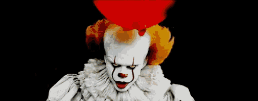 a close up of a clown with red hair and a red balloon in his head .