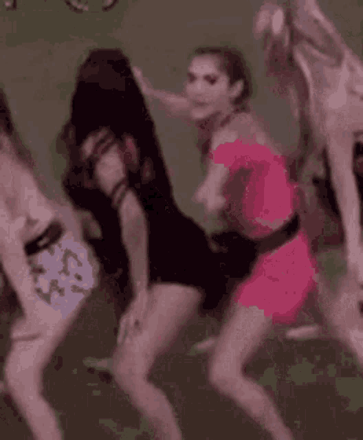 a group of women are standing next to each other and dancing on a green background .