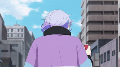 a woman in a purple shirt is walking down a street